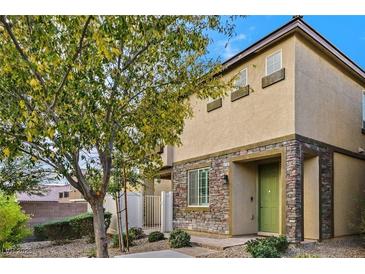 Inviting two-story home featuring stone accents, manicured landscaping, and a charming green front door at 6110 Scarlet Leaf St, Las Vegas, NV 89148