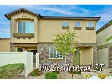 Inviting two-story home featuring stone accents and a well-manicured front yard at 6110 Scarlet Leaf St, Las Vegas, NV 89148