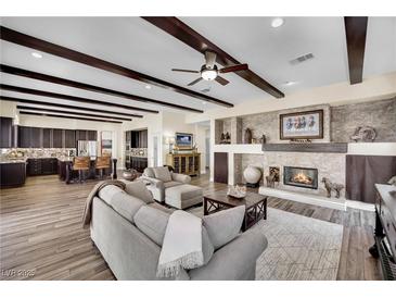 Cozy living room features dark wood beam ceiling, fireplace, and views to kitchen at 296 Brushy Creek Ave, Las Vegas, NV 89148
