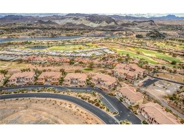 Stunning aerial view of a community with golf course, lake, and mountain backdrop at 64 Strada Principale # 307, Henderson, NV 89011
