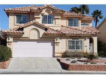 Inviting two-story home with a terra cotta tile roof, a well-manicured lawn and a two car garage at 8982 Emerald Waters Ct, Las Vegas, NV 89147