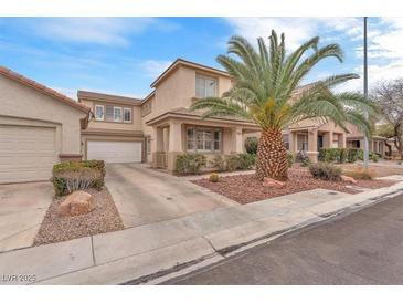 Charming two-story home with a well-manicured lawn and a large palm tree in the front yard at 9788 Altadena St, Las Vegas, NV 89183