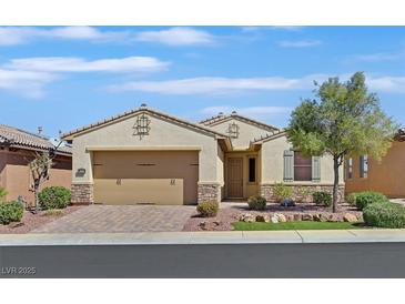Charming single-story home featuring a manicured front yard, brick driveway, and a two-car garage at 1026 Via Saint Andrea Pl, Henderson, NV 89011