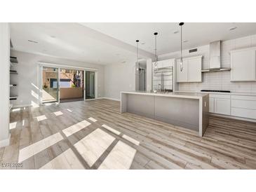 Bright, open-concept living area flows into a modern kitchen with an island and has a sliding door to a patio at 11280 Granite Ridge Dr # 1101, Las Vegas, NV 89135