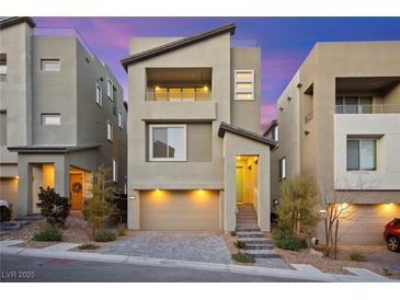 Contemporary two-story home featuring neutral stucco, a two-car garage, and a welcoming entrance with stylish landscaping at 11676 Midnight Melody Ave, Las Vegas, NV 89138