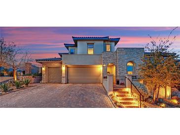 Beautiful two-story home featuring a three-car garage, stone accents, and lush landscaping at 11878 Albissola Ave, Las Vegas, NV 89138