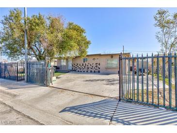 Charming single-story home featuring a gated front yard and spacious driveway at 2054 Harvard St, North Las Vegas, NV 89030