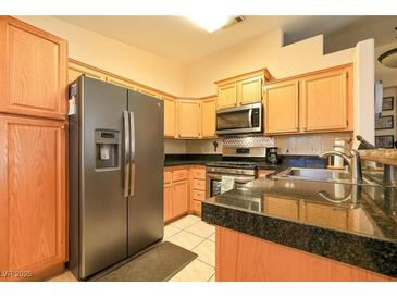 Well-lit kitchen features stainless steel appliances, light wood cabinets, and granite countertops at 2110 Los Feliz St # 2064, Las Vegas, NV 89156