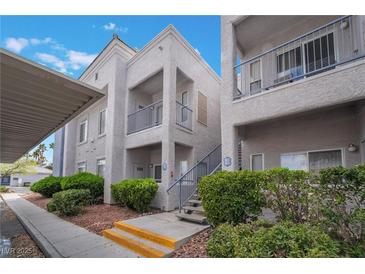 Inviting condo with private balcony, fresh paint and lush landscaping creates a welcoming curb appeal at 2201 Ramsgate Dr # 823, Henderson, NV 89074