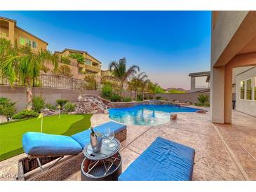 A luxurious backyard oasis featuring a stunning pool, spa, and comfortable lounge seating area at 28 Vista Outlook St, Henderson, NV 89011