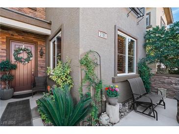 Charming home entrance with a decorative wreath on the door and lovely landscaping at 3185 Mura Del Prato Ave, Henderson, NV 89044