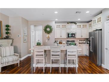 Bright kitchen with white cabinets, stainless steel appliances, and an island with bar seating at 3185 Mura Del Prato Ave, Henderson, NV 89044