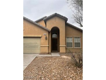 Inviting home exterior with neutral tones, desert landscaping, and a charming, covered entryway at 4824 Quartz Crest St, North Las Vegas, NV 89081