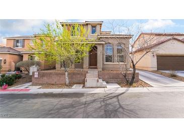 Two-story tan home featuring a brick front wall and a well-maintained lawn with mature trees at 9119 Brilliant Prairie Ct, Las Vegas, NV 89149