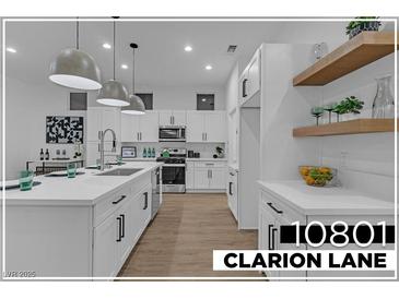 Bright modern kitchen boasts white cabinets, stainless steel appliances, and a functional center island at 10801 Clarion Ln, Las Vegas, NV 89134