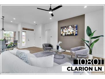 Bright living room featuring a modern ceiling fan, a wall-mounted TV, and stylish contemporary furnishings at 10801 Clarion Ln, Las Vegas, NV 89134