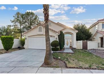 Charming single-story home features a well-manicured lawn, front garden, and an attached two-car garage at 1229 Triumph Ct, Las Vegas, NV 89117