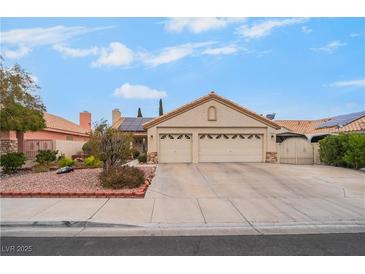 Charming single-story home with a two-car garage, desert landscaping, and a tile roof at 213 Red Coral Dr, Henderson, NV 89002