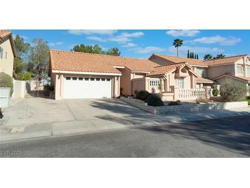Charming single-Gathering home featuring a tile roof, a two-car garage, and a well-maintained front yard landscape at 3040 Ocean Port Dr, Las Vegas, NV 89117