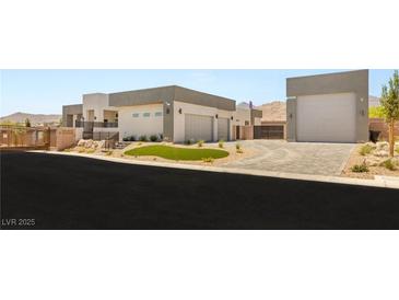 Modern home with a circular driveway, multiple garages, and desert landscaping at 5719 Christian Creek Ct, Las Vegas, NV 89149