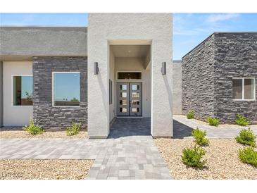Contemporary home with a modern entrance featuring stone accents, neutral colors, and a walkway at 5719 Christian Creek Ct, Las Vegas, NV 89149