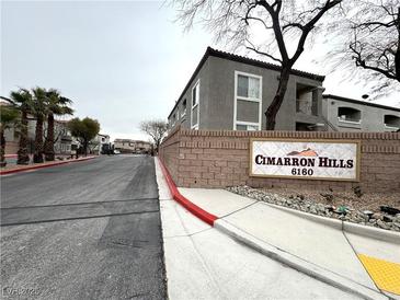 Cimarron Hills community sign with condo buildings in the background and street view at 6160 Rumrill St # 207, Las Vegas, NV 89113