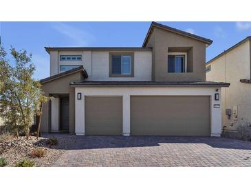 Two-story home with a modern design, neutral color palette, two-car garage, and low maintenance rock landscaping at 10122 Mystic Falls Dr, Las Vegas, NV 89141