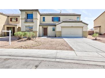 Inviting two-story home with a neutral stucco facade, attached garage and minimal landscaping at 1021 Gary Carmena Ave, North Las Vegas, NV 89081