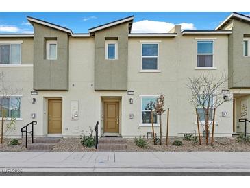 Newly constructed townhomes with neutral exteriors, desert landscaping, and private entrances at 2949 White Selzter Ct, Las Vegas, NV 89122