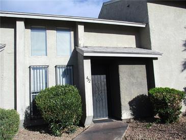 Two-story townhouse with neutral stucco, mature shrubbery, and covered front entry with security door at 432 Sellers Pl, Henderson, NV 89011