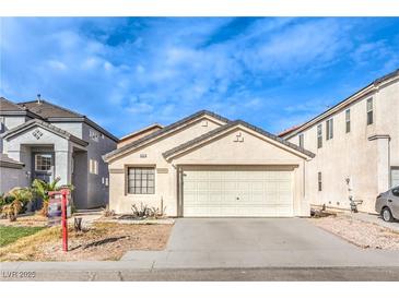 Beige single-story home with a two-car garage and simple landscaping, nestled in a residential neighborhood at 4381 Coyote Crest Ct, Las Vegas, NV 89147