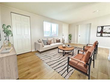 Bright living room with neutral tones, modern furniture, and wood-style flooring at 604 N Minnesota St, Las Vegas, NV 89107
