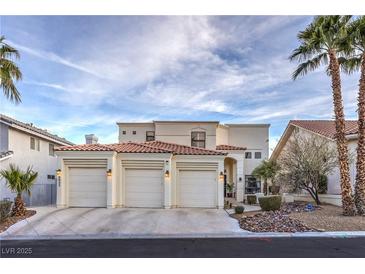 Stunning stucco home featuring a three-car garage, desert landscaping, and a red tile roof at 8032 Marbella Cir, Las Vegas, NV 89128