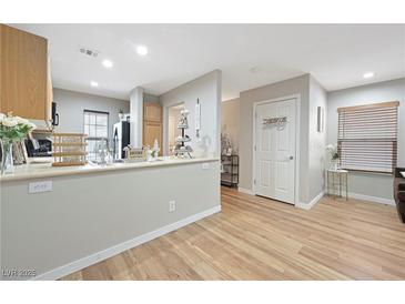 Bright kitchen featuring an open layout, light wood cabinets, and a breakfast bar with decorative accents at 9053 Pearl Cotton Ave, Las Vegas, NV 89149