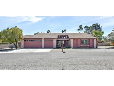Charming single-story home featuring a well-maintained front yard, a two-car garage and a welcoming entryway at 2221 Mohawk St, Las Vegas, NV 89146