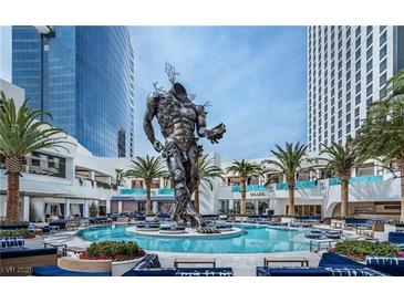 Stunning pool area with a massive statue surrounded by lounge seating and palm trees at 4381 W Flamingo Rd # 1510, Las Vegas, NV 89103