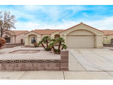 Charming single story home featuring a two car garage, landscaped yard, and a red tile roof at 5033 Chambliss Dr, Las Vegas, NV 89130