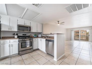 Well-lit kitchen featuring white cabinets, stainless steel appliances, and an open layout at 8070 W Russell Rd # 2015, Las Vegas, NV 89113