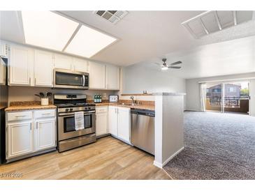 Bright kitchen featuring stainless steel appliances, white cabinets and updated counter tops at 8070 W Russell Rd # 2015, Las Vegas, NV 89113