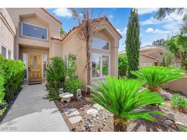 Charming home featuring mature landscaping, a concrete walkway, and a decorative front door at 8170 Round Hills Cir, Las Vegas, NV 89113