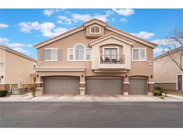 Inviting townhome with a private balcony and three-car garage spaces, complemented by manicured landscaping at 10086 Aspen Rose St # 101, Las Vegas, NV 89183