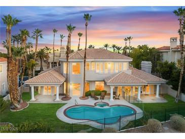 Stunning backyard featuring a pool, spa, and lush landscaping, perfect for outdoor entertaining and relaxing in luxury at 2221 Glenbrook Way, Las Vegas, NV 89117