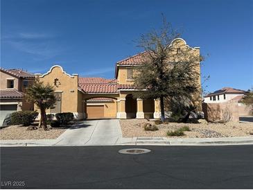 Two-story stucco home featuring a red tile roof, arched entryway, desert landscaping, and two-car garage at 2628 Park Hyatt Ave, North Las Vegas, NV 89081
