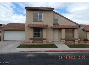Charming two-story home featuring a red tile roof, a two-car garage, and a well-maintained front yard at 2711 Sesame Dr, Las Vegas, NV 89142