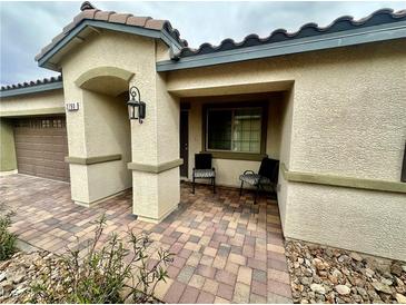 Charming single story home with covered entryway and two chairs on a brick paver landing at 2790 Chetco River St, Laughlin, NV 89029