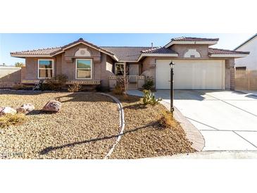 Charming single-story home featuring desert landscaping, tile roof, and attached two-car garage at 5552 Singing Hills Dr, Las Vegas, NV 89130