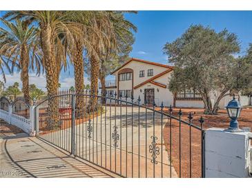 Charming home featuring a two-story design, mature landscaping, and a gated driveway for added privacy at 7079 Laredo St, Las Vegas, NV 89117