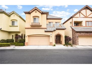 Charming two-story home featuring tan stucco, arched entryway, and convenient two-car garage at 9172 Tudor Park Pl, Las Vegas, NV 89145