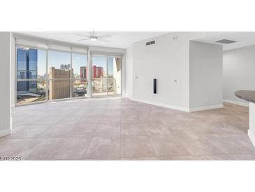 Bright living room with floor-to-ceiling windows offering panoramic city views and access to a private balcony at 200 W Sahara Ave # 3004, Las Vegas, NV 89102