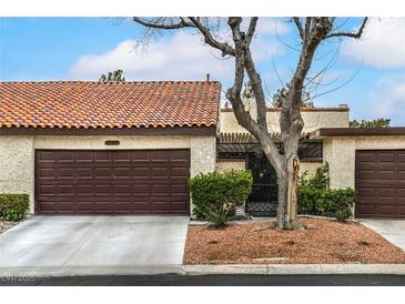 Charming single-story home featuring a brown garage door, stucco walls, and a red tile roof at 3053 Conquista Ct, Las Vegas, NV 89121